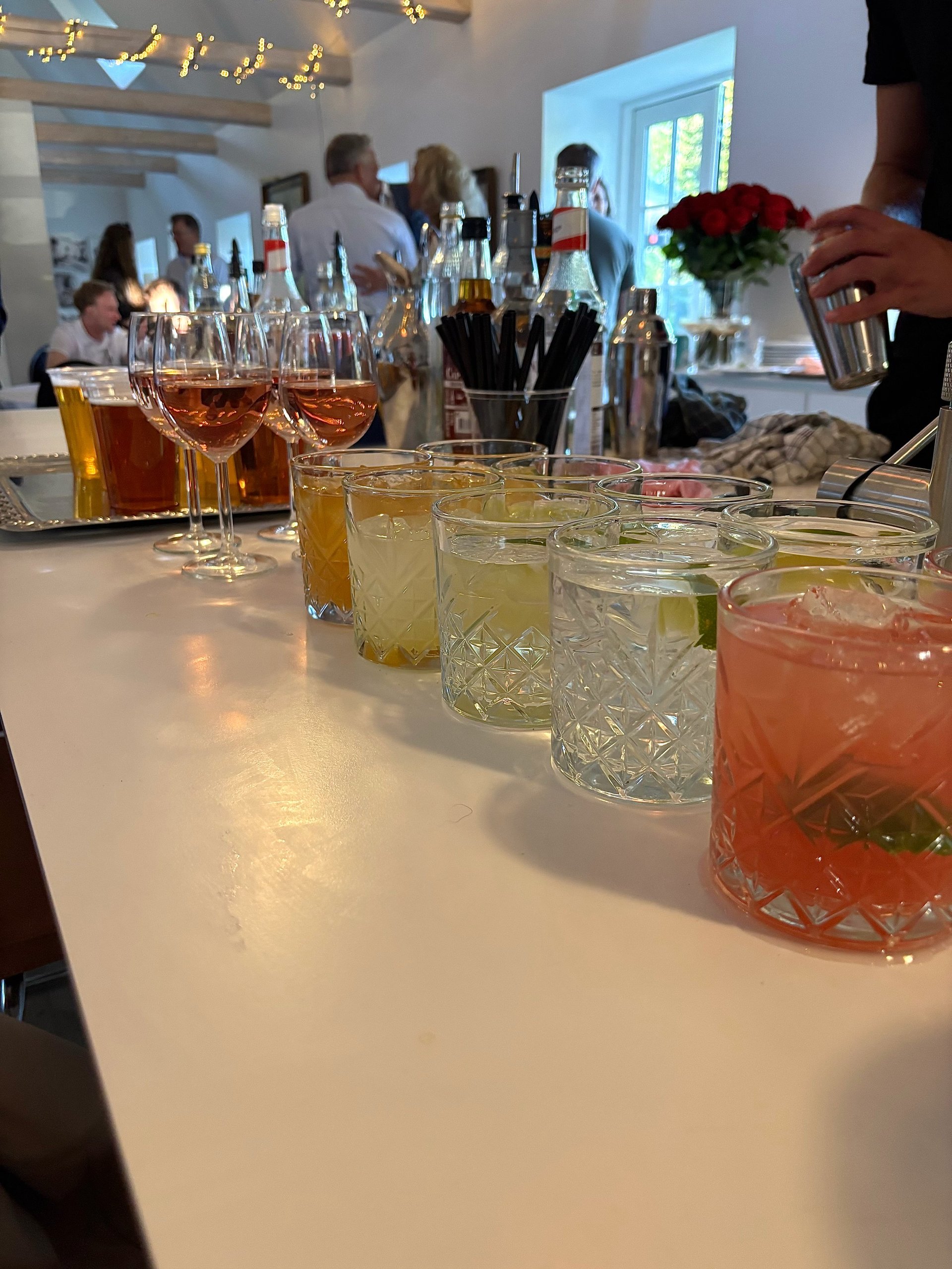 Cocktails og drinks på disk med gæster i baggrunden