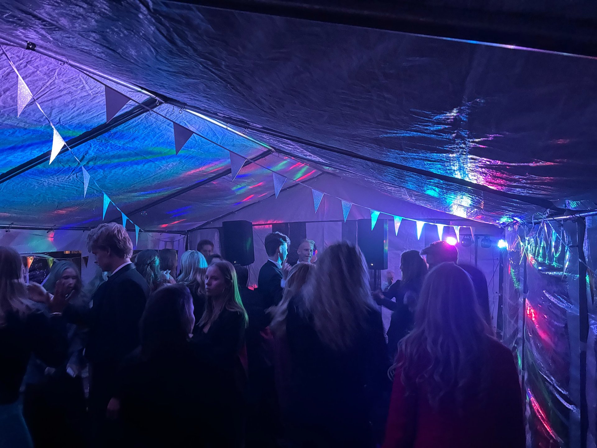 Tranglet indendørs natklub med neonlys og dansende gæster